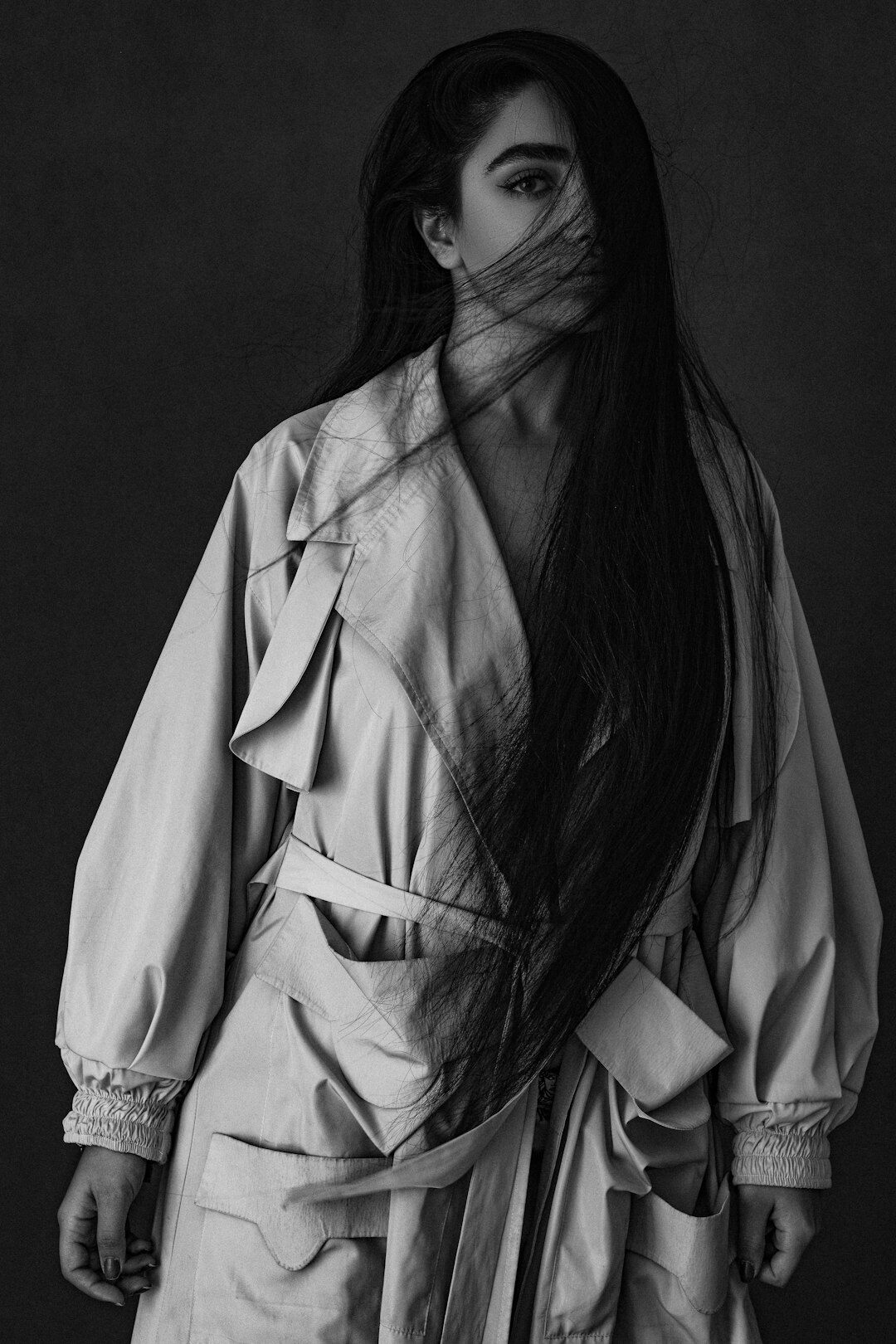 Studio portrait of a woman with long dark hair wearing a white lab coat